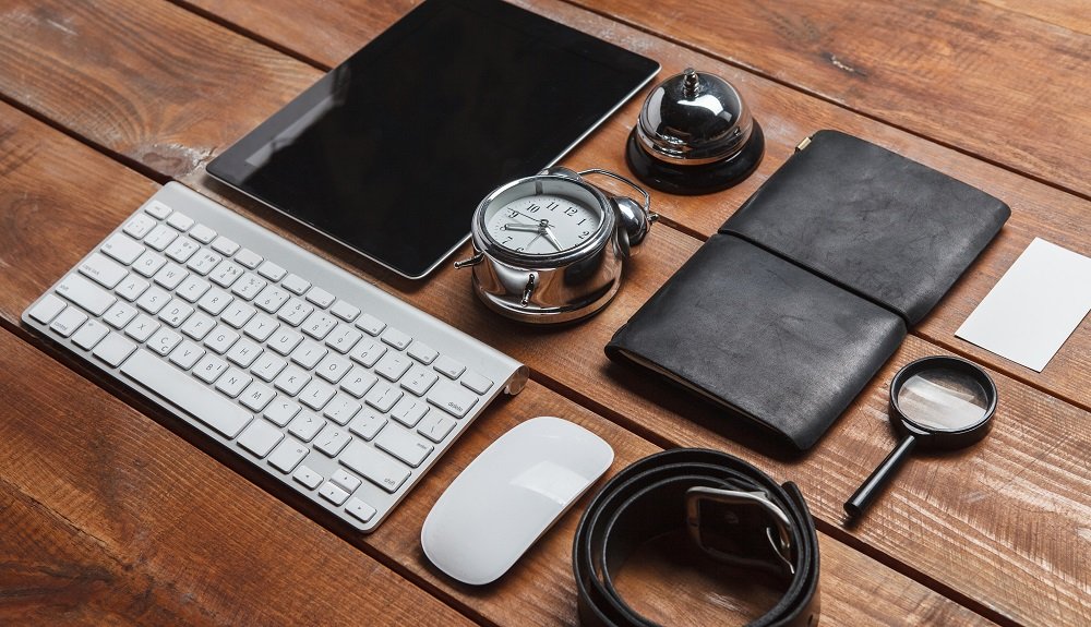 Men's accessories - laptop, keyboard, mouse, partmane, belt, clock on the wooden table